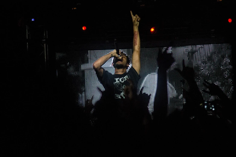 person in a black shirt is raising their hand at an event