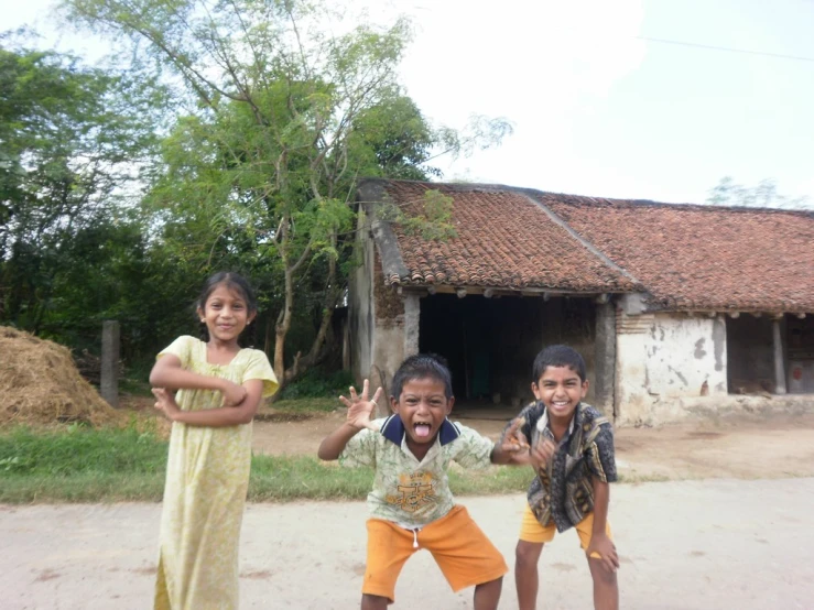 three children standing in front of a building