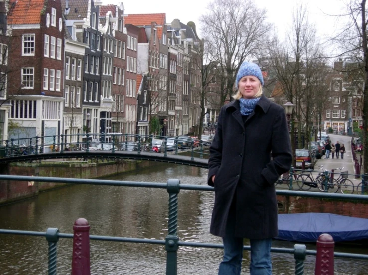 a woman standing on a railing near a canal