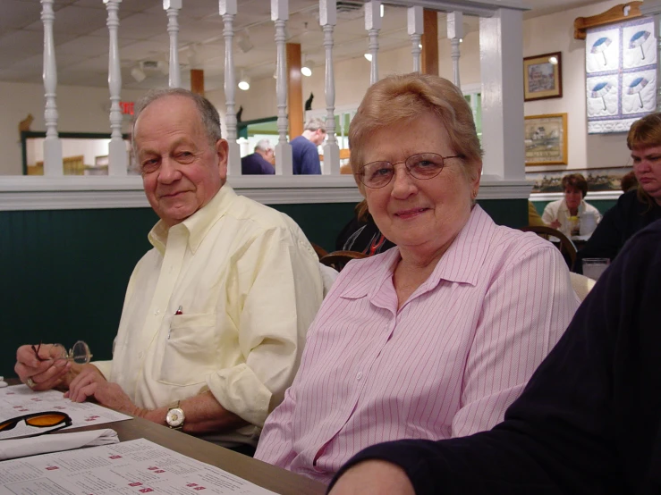 a man and woman sitting next to each other at a table