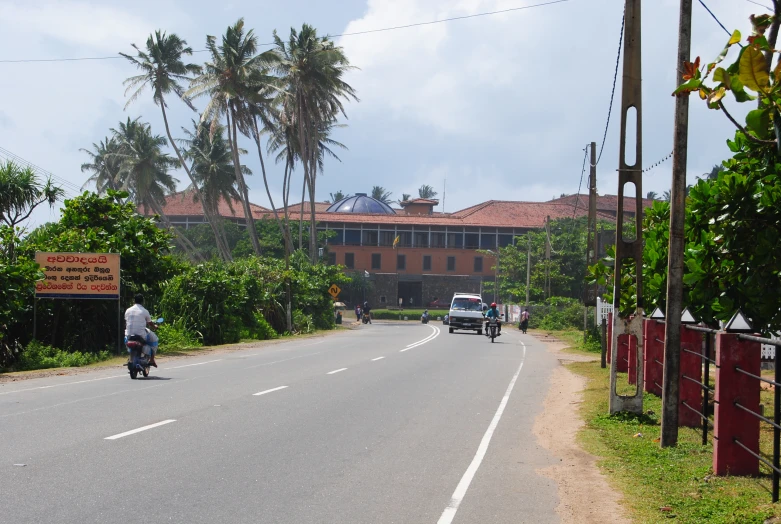 a person riding a motorcycle down a road with trees