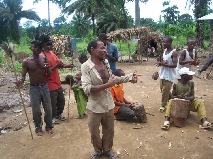 man in village looking at camera while another man talks