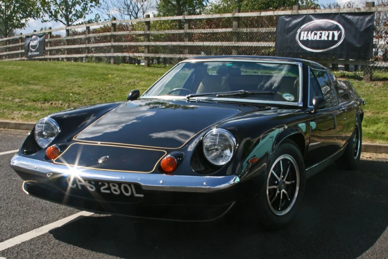 a black and gold colored sports car sits in a lot