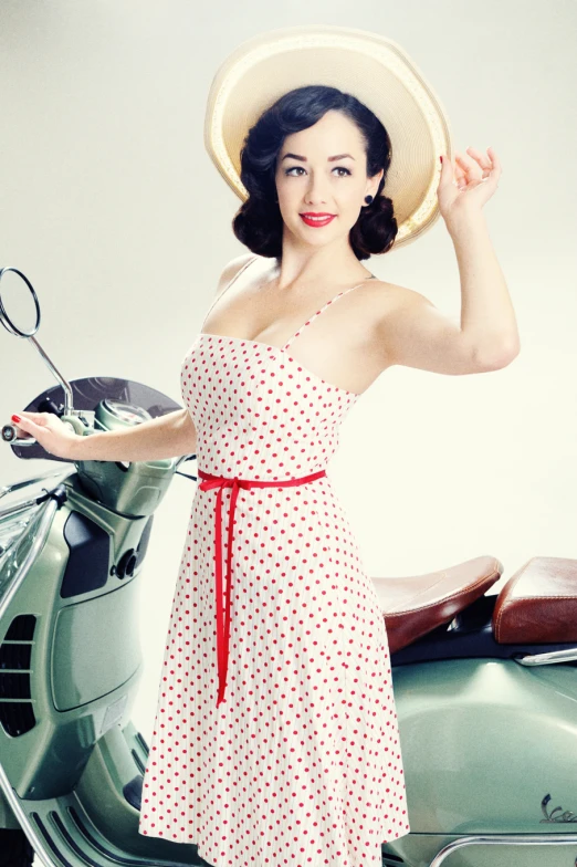a young woman stands in front of a scooter, posing with her hands behind her head