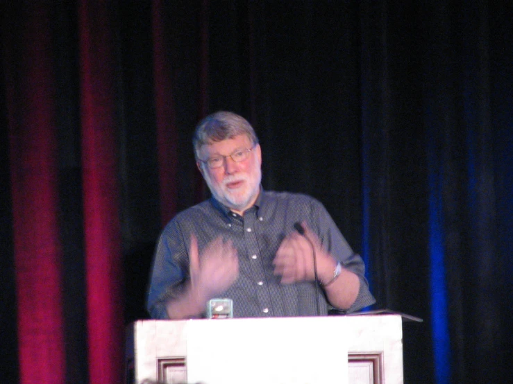 a man is giving a presentation at a podium