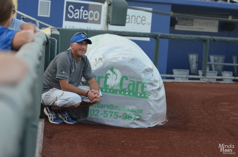 a man sitting in a dugout at a baseball field