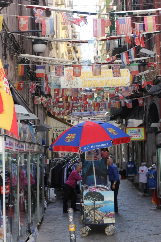 a narrow city alley with some hanging colorful cloths