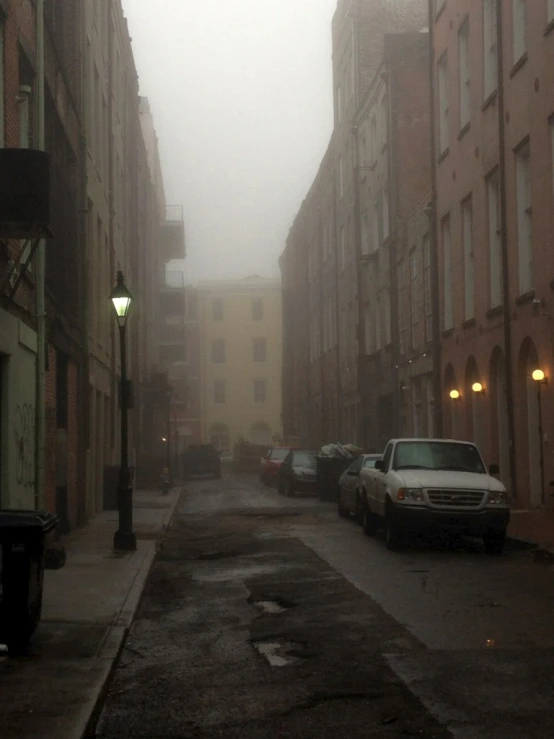 cars parked on street in the middle of a town during daytime