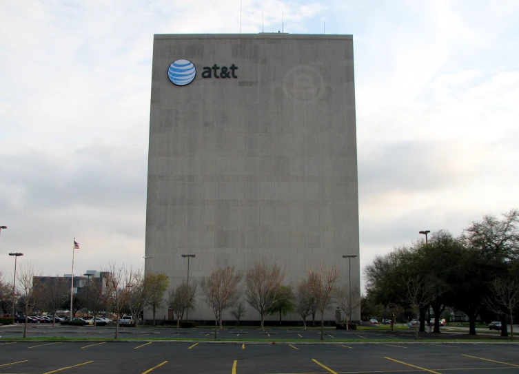 the large building is located by some trees and the sky