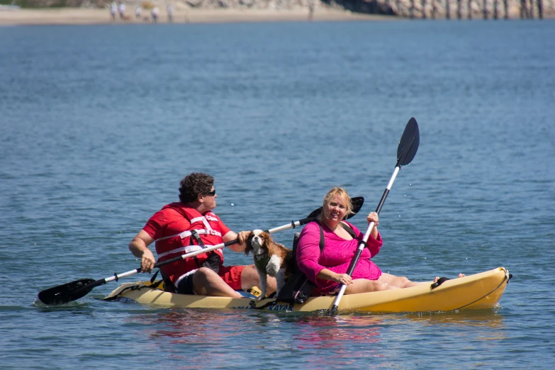 a man and woman with a dog on a kayak