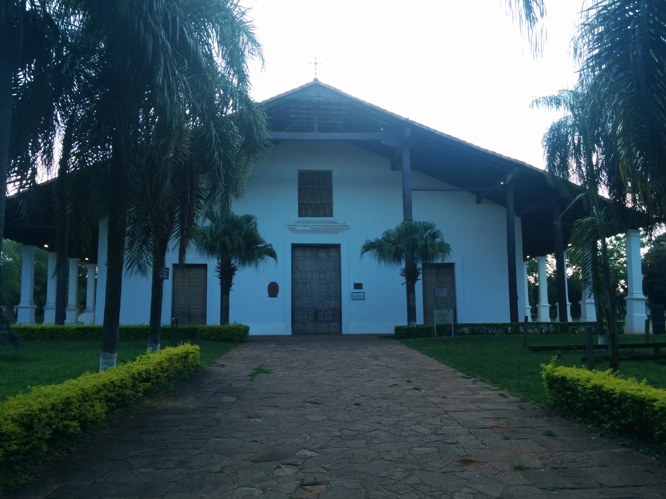 a building surrounded by palm trees on a clear day