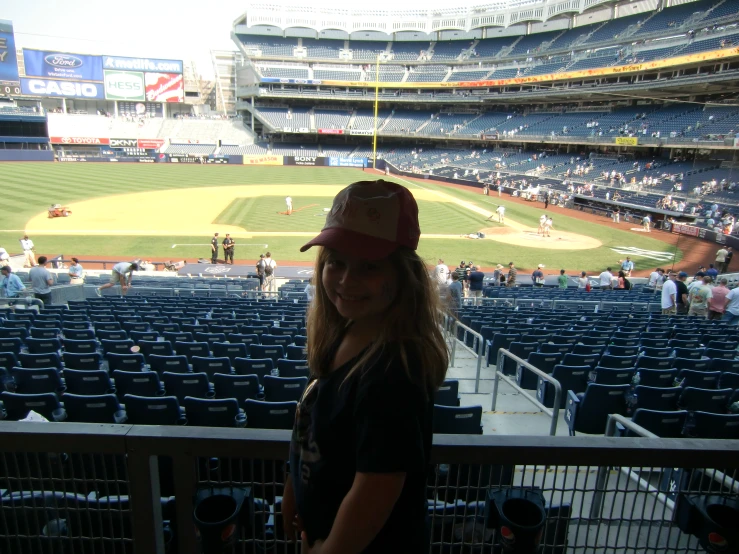 the young woman poses in front of an empty stadium