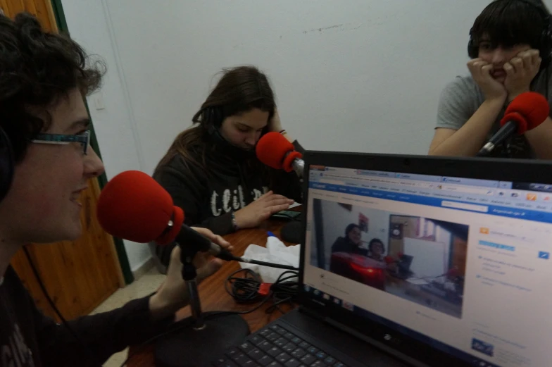 a microphone is hanging near two people in a recording studio