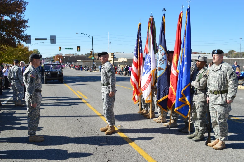 soldiers line up in the street with their flag