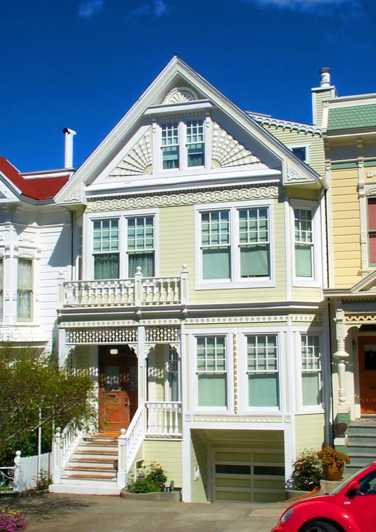 a red car is parked in front of many houses