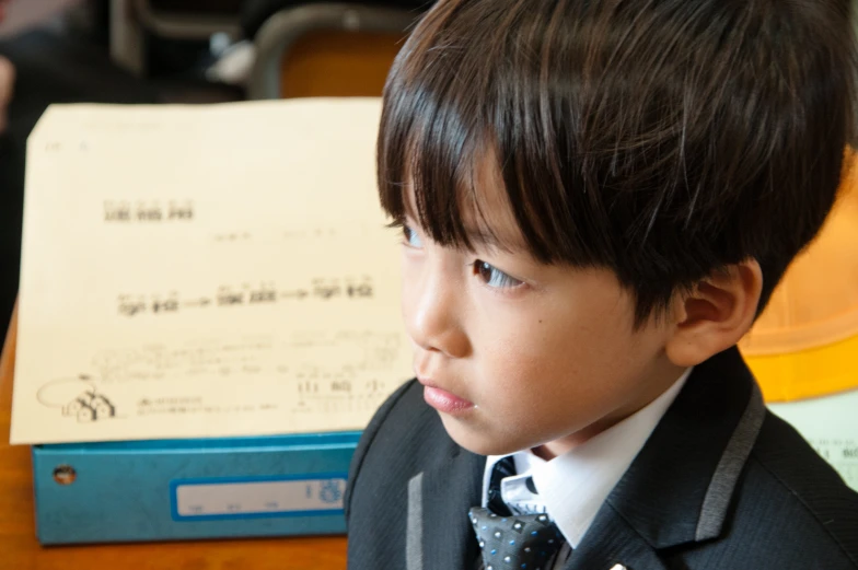 there is a little boy wearing a suit and tie