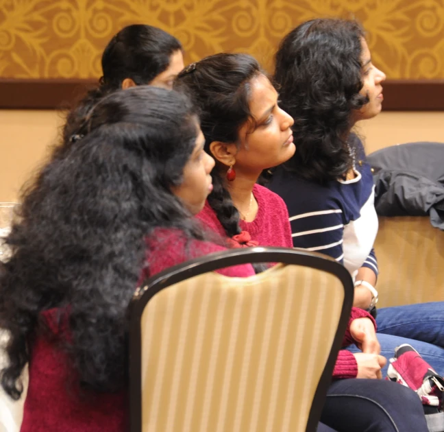 several people sit together at a table talking