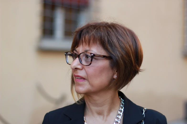 an attractive lady looking intently down while wearing glasses