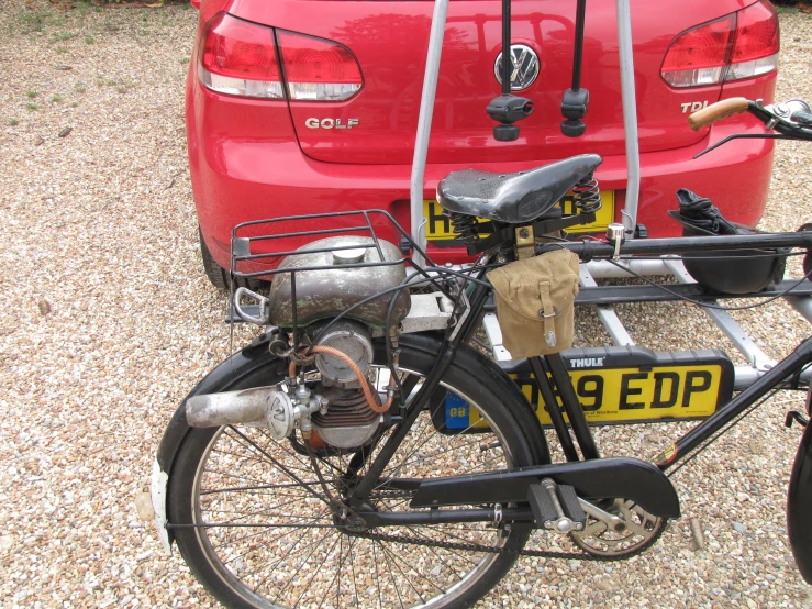 a bicycle is parked in front of two parked cars