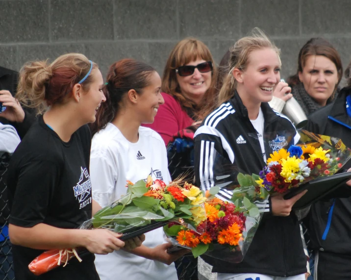 the woman on the team is holding flowers