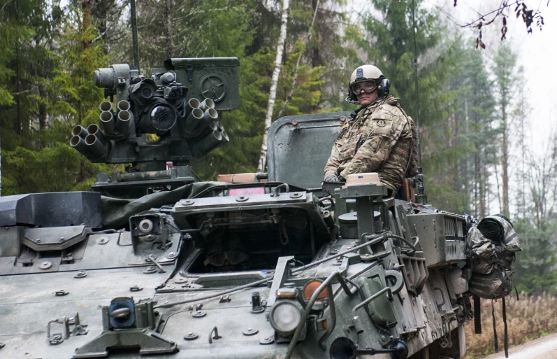 a man in army fatigues on a military tank