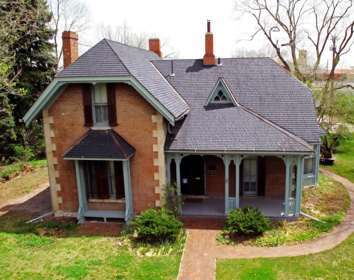 a home with red brick and two dorm windows