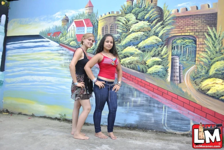 two girls in front of a colorful wall posing for a po