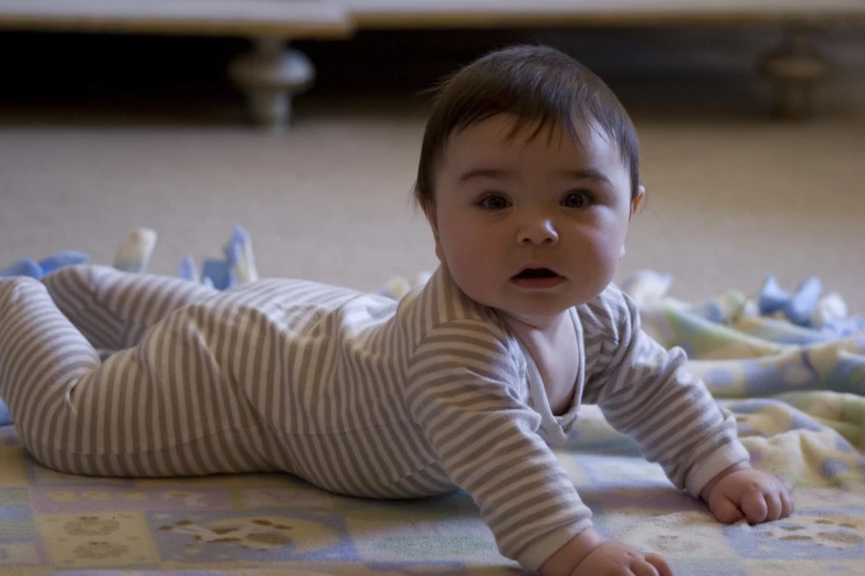 a baby laying on a bed in pajamas