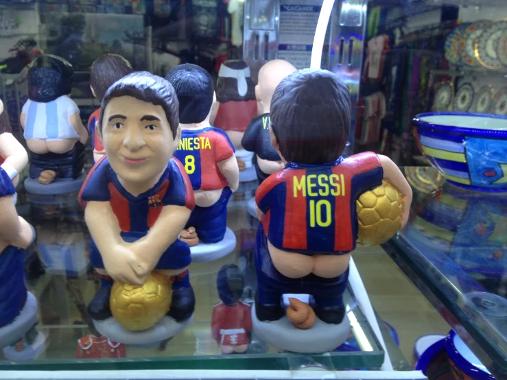 a display case with toy soccer figurines holding balls