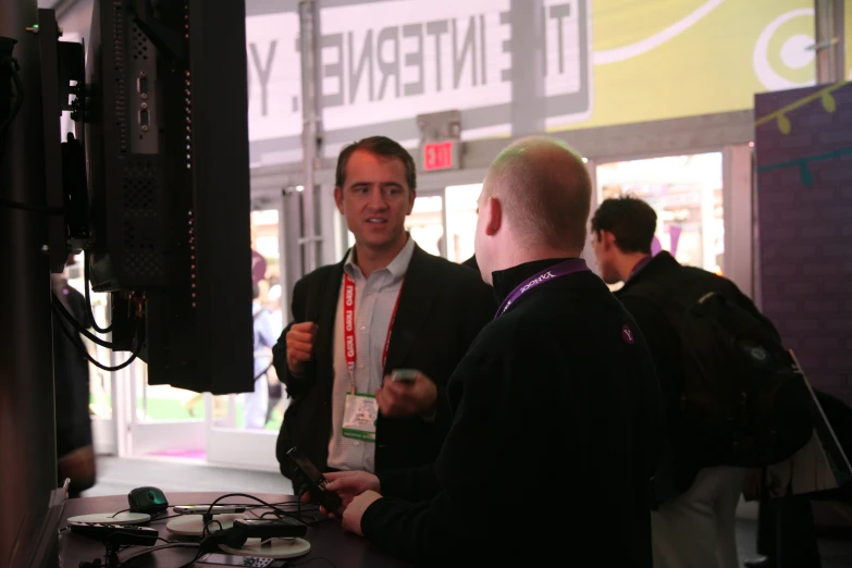 men standing around a counter talking and having conversation