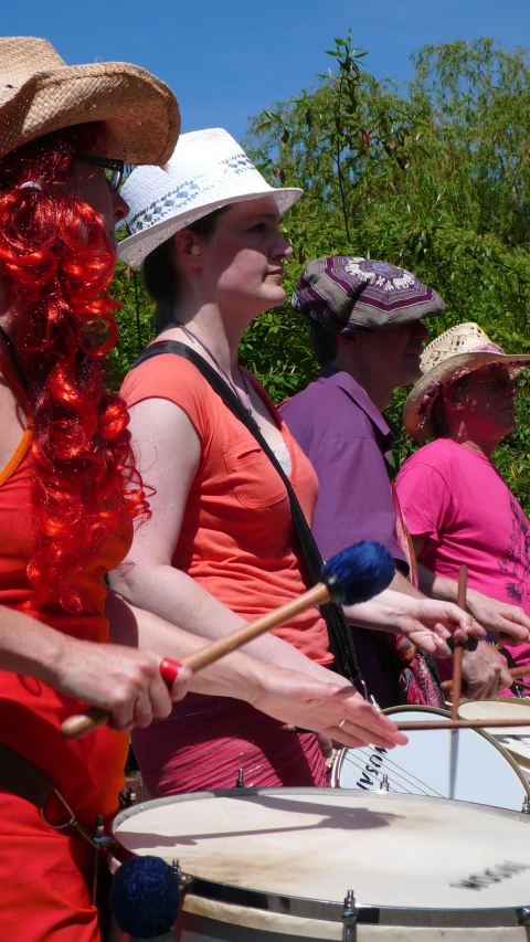 a group of women in cowboy hats and orange dress