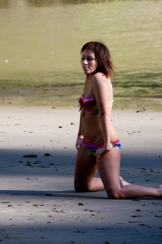 a girl in a swim suit sits on the ground