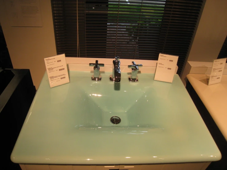 a green bathroom sink with a faucet and faucets