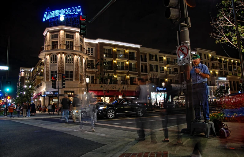 people stand on the side walk looking at their cellphones