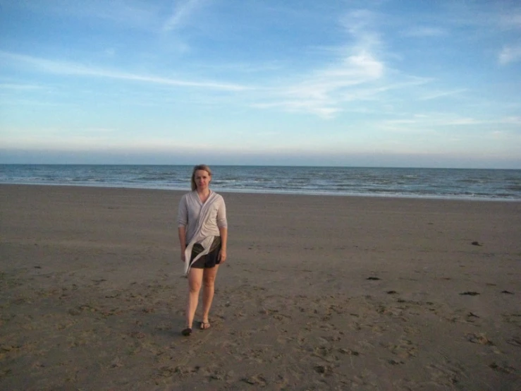 woman standing on beach near the ocean on clear day