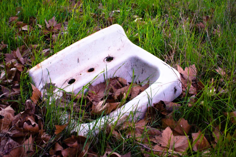 an old broken sink in the middle of a field