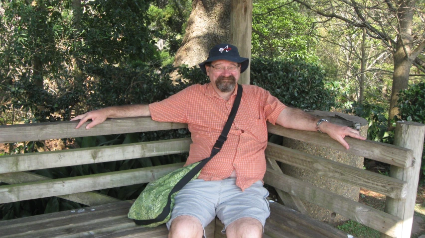 an old man with his hands on the back of a bench