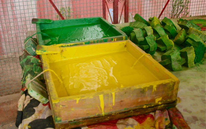 a wooden box with yellow paint next to other pieces of wood