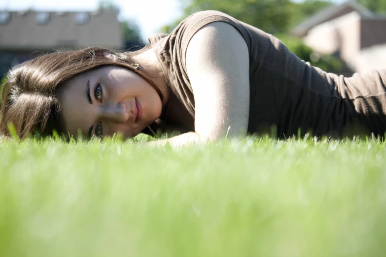 a girl lying in the grass on the ground