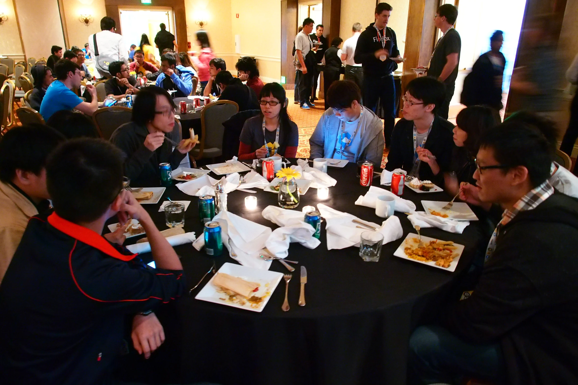 people sitting at table with drinks and food