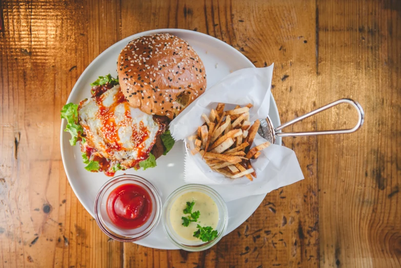 burger and fries on a white plate on a table