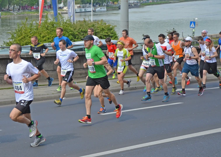 people running down a road with a lot of water in the background