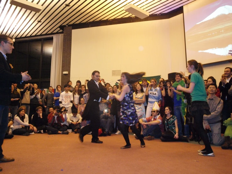 two people dressed in black dance on the stage