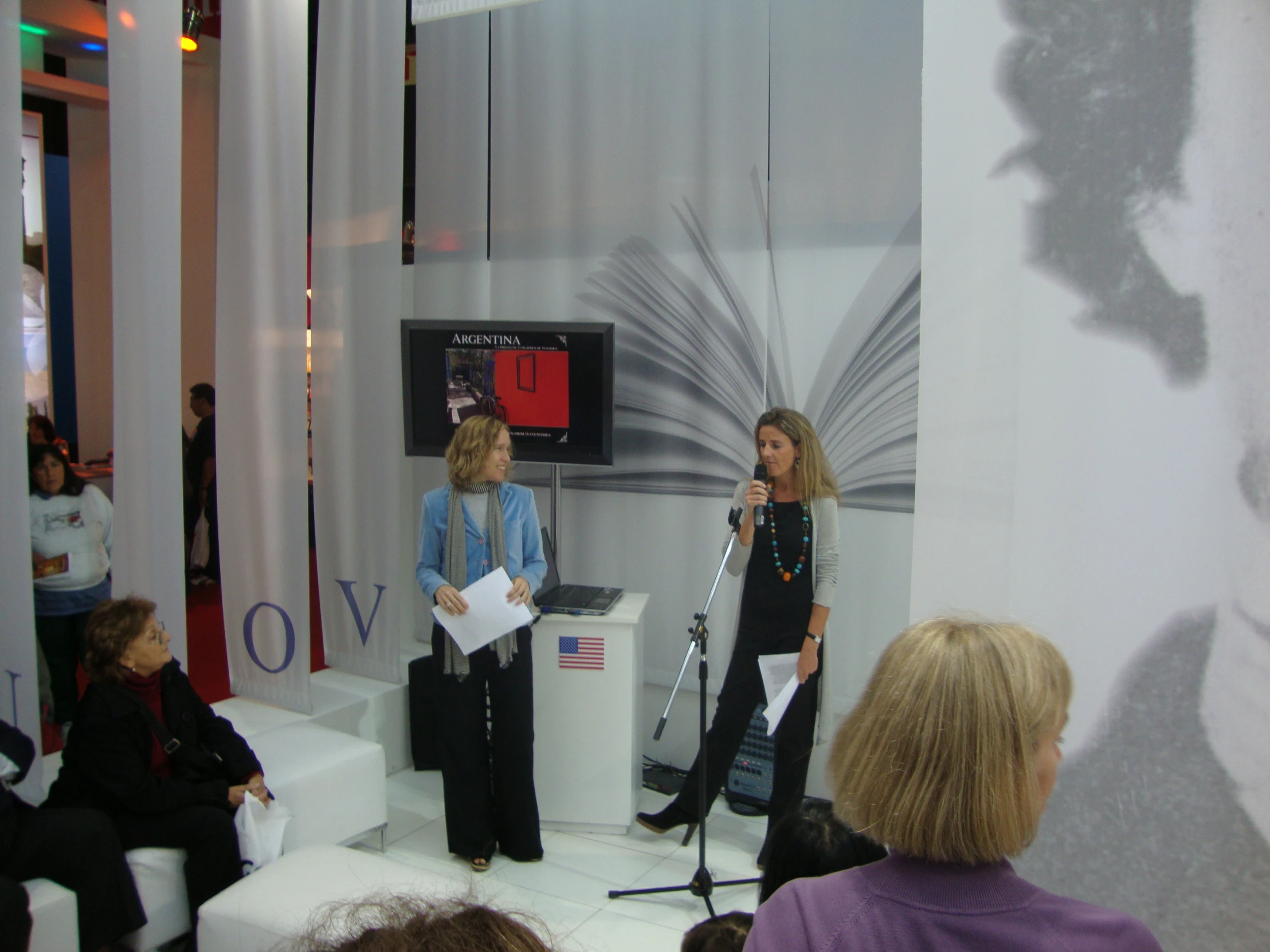 two woman are on a stage talking to each other