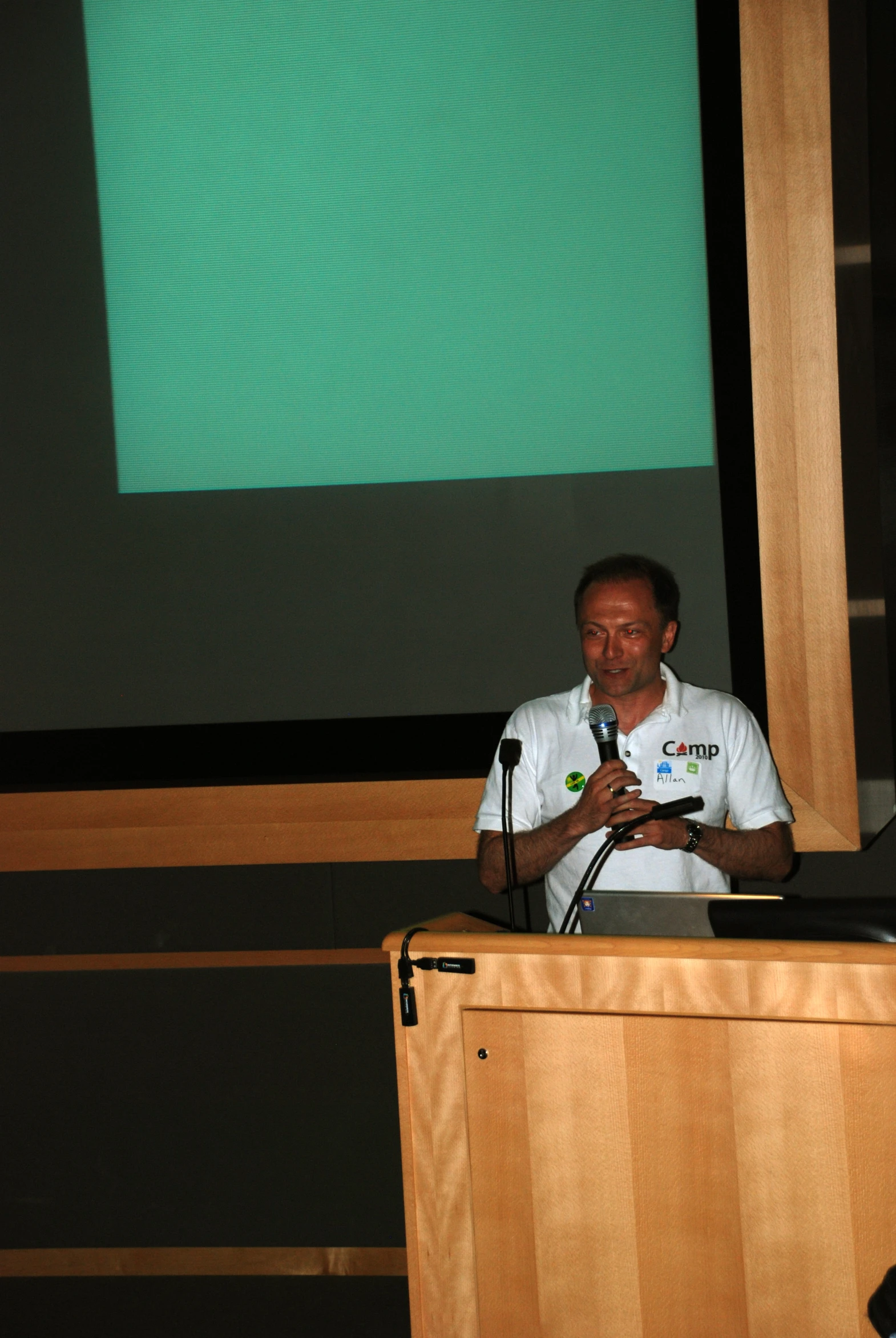 a man on stage making a presentation about computer repair