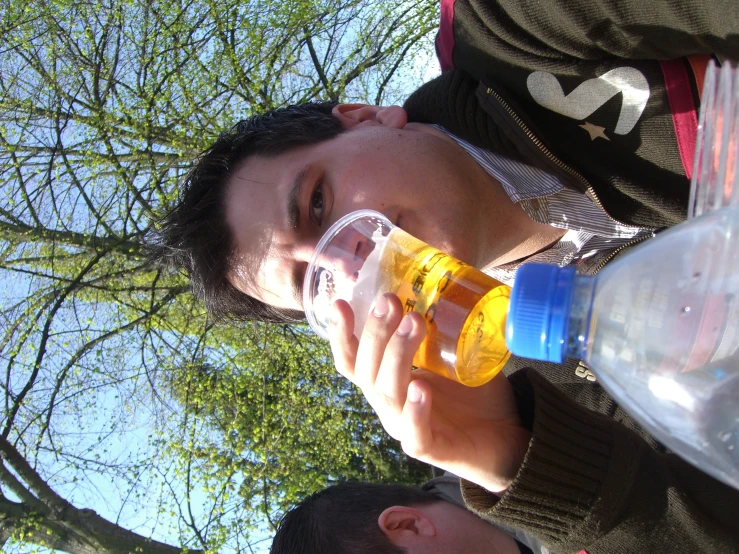 a young man holds up two water bottles