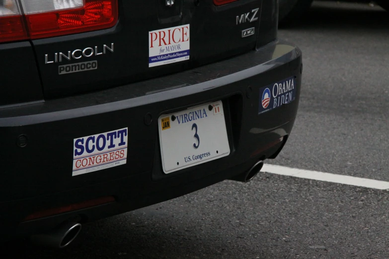 a couple of license plates on the back of a black car