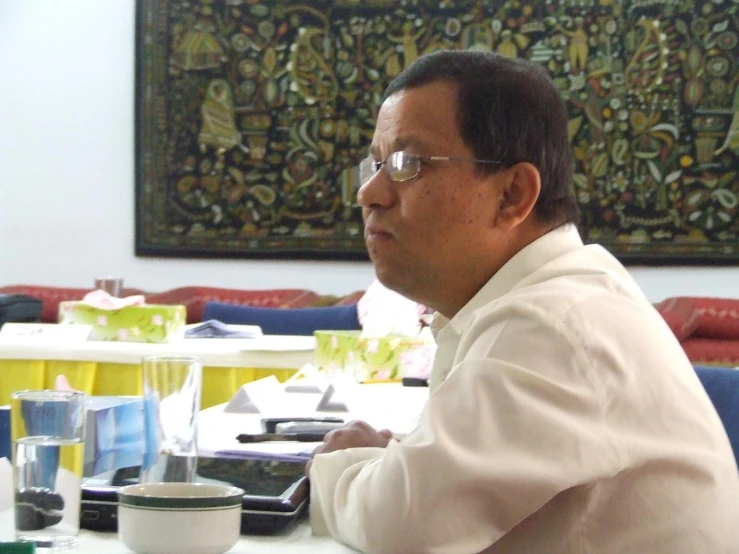 an older man wearing a white shirt and glasses