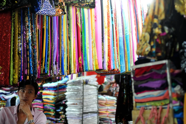 a man with a hat in front of colorful ribbons