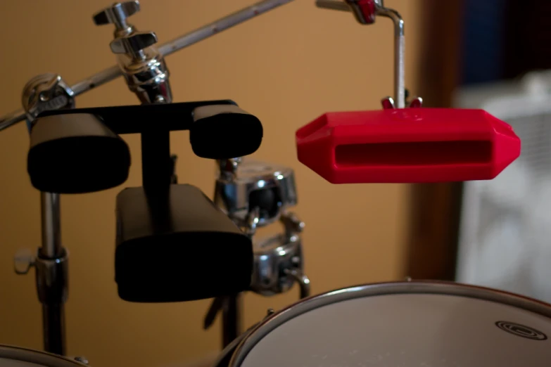 a pair of drums stand next to a red object